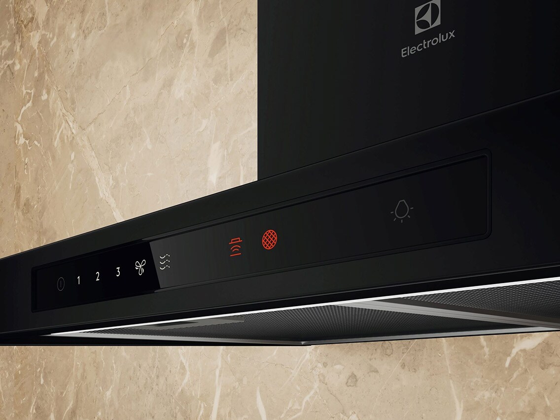 Närbild på kontrollpanelen på en svart köksfläkt från Electrolux mot en marmorbakgrund.