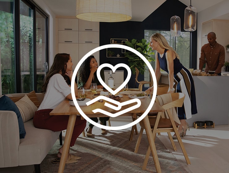 Ikon med en hand som håller i ett hjärta ovanpå en bild med människor som pratar